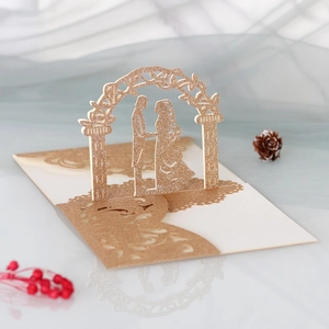 Makrodetail der lasergeschnittenen 3D-Hochzeitskarte in Champagnergold mit Brautpaar-Silhouette