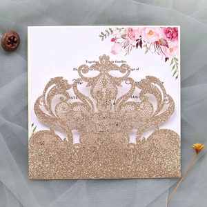 Macro detail of laser-cut glitter wedding invitation with champagne gold floral patterns
