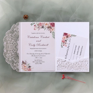 Intricate laser-cut wedding invitation featuring watercolor floral inserts and RSVP card
