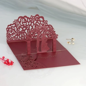 Dettaglio macro di un biglietto di nozze 3D bordeaux con delicati motivi a rosa laser