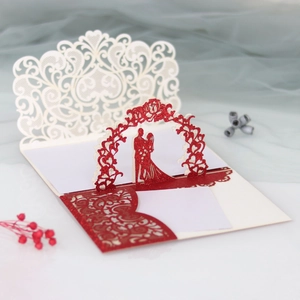 Detail of 3D laser cut wedding invitation with red glitter silhouette and lace pattern