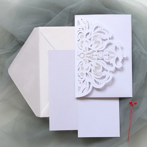 Detail of white laser-cut wedding invitation set with elegant baroque lace pattern