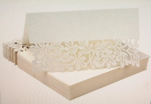 Detailed laser-cut floral pattern on white pearlescent paper wedding table cards