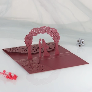 Laser cut 3D wedding card with red rose arch and couple silhouette detail