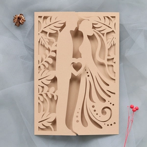 Detail of laser-cut wedding invitation featuring a romantic couple silhouette and heart