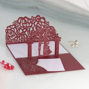 Dettaglio invito nuziale 3D intagliato al laser con silhouette di sposi e decori rose