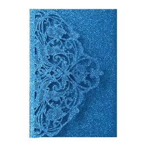 Close-up of glittery blue laser-cut wedding invitation card with intricate lace details