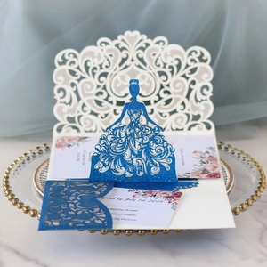 Detail of laser cut wedding invitation with navy glitter bride silhouette on elegant tray
