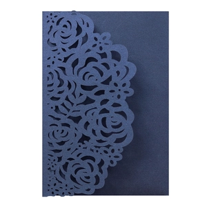 Dettaglio dell'invito blu scuro tagliato al laser con elaborato motivo floreale a rose
