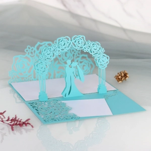 Detailed laser-cut 3D pop-up wedding card featuring a blue rose arch and couple silhouette