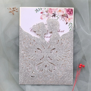 Detailed laser-cut silver glitter wedding invitation with groom and bride silhouette