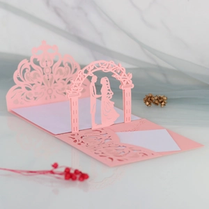 Macro detail of 3D laser-cut wedding invitation featuring a romantic pink arch design