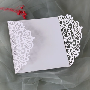 Detail of laser-cut ivory butterfly wedding invitation with elegant floral lace patterns