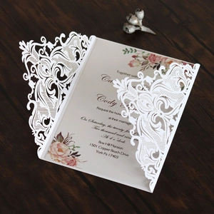 Detail of laser-cut filigree wedding invitation with elegant floral inner card design