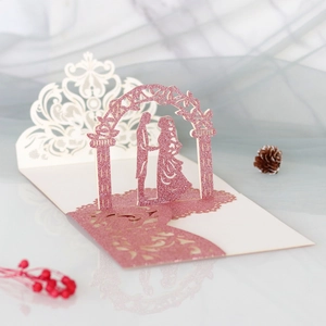 Makroaufnahme einer 3D-Hochzeitskarte mit rosa Glitzer-Spitze und Laser-Cut-Bogen-Design