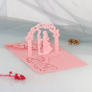 Detail view of 3D laser cut pink wedding invitation with romantic lace hollow pattern