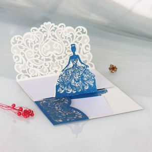 Detail of laser-cut paper greeting card featuring a blue glitter pop-up princess dress