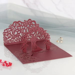 Dettaglio invito nozze 3D intagliato al laser con rose rosse e sagoma di coppia romantica