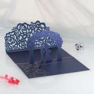 Detail of laser-cut floral arch and 3D silhouette on navy blue wedding invitation