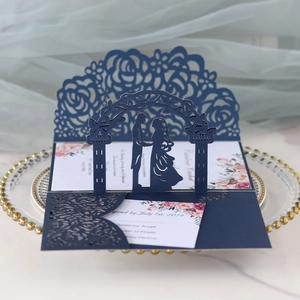 Dettaglio dell'invito di nozze blu navy tagliato al laser con sagoma degli sposi eleganti