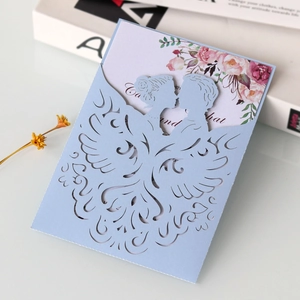 Light blue laser cut wedding invitation featuring a silhouette of a kissing couple