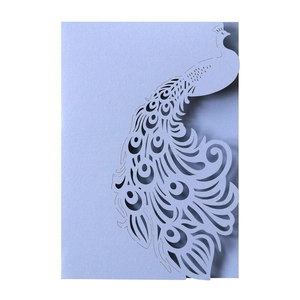 Detailed laser-cut peacock wedding invitation with shimmering light blue pearlescent paper