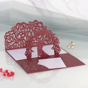 Dettaglio dell'invito di nozze bordeaux tagliato al laser con rose e silhouette di coppia