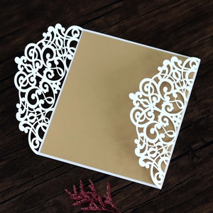 Detail of laser-cut butterfly invitation with white lace pattern and gold inner card