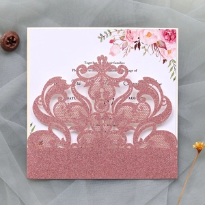 Detail of pink glitter laser cut wedding invitation with floral watercolor inner card