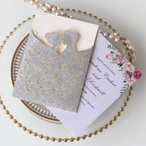 Detailed laser-cut silver glitter wedding invitation with purple floral inner card