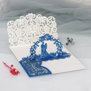 Detail of 3D laser-cut wedding invitation featuring a glittery blue lace floral cover