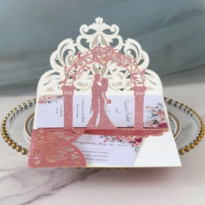 Macro view of 3D laser-cut rose gold glitter wedding invitation with floral insert