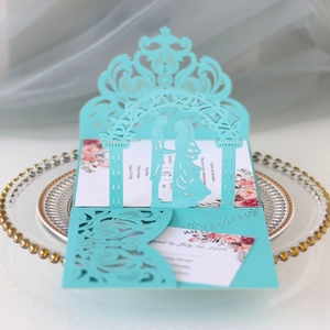 Detail view of light blue laser cut wedding invitation with 3D bride and groom silhouette