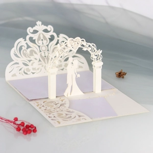 Detail of 3D laser-cut wedding invitation featuring a romantic couple and lace patterns