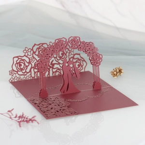 Detail of 3D laser-cut wedding card featuring a romantic couple under a rose arch