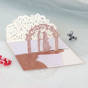 Macro detail of laser-cut rose gold glitter wedding card with 3D bride and groom pop-up