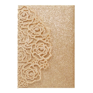 Detail of laser-cut rose patterns on elegant golden glitter wedding invitation card