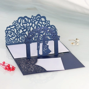 Dettaglio dell'invito di nozze blu navy intagliato al laser con silhouette di coppia 3D