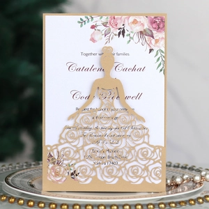Detail of laser-cut gold wedding invitation featuring lace rose bridal silhouette