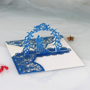 Detail of 3D laser cut wedding invitation with blue glitter finish and romantic couple scene