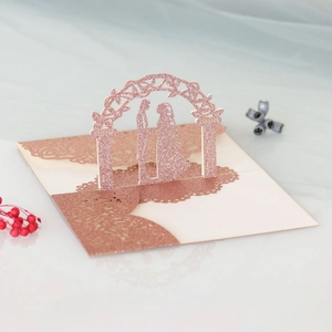 Detail of laser-cut 3D rose gold glitter wedding card with pop-up couple and lace base