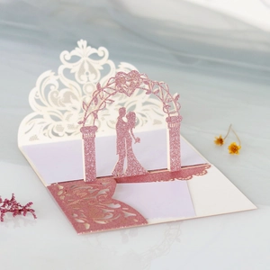 Detail of 3D pop-up wedding invitation featuring laser-cut silhouettes and rose gold glitter