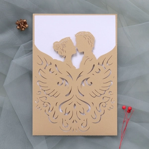 Detail of laser-cut wedding invitation featuring a romantic couple kissing design