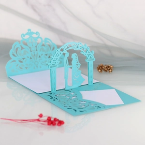 Detail of light blue laser-cut 3D wedding invitation with couple and floral lace