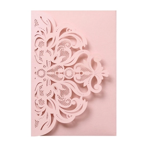Detail of pink laser-cut lace wedding invitation with pearl shimmer and floral patterns