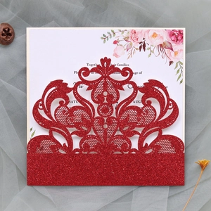 Detail of red glitter laser-cut wedding invitation card with floral insert on mesh fabric