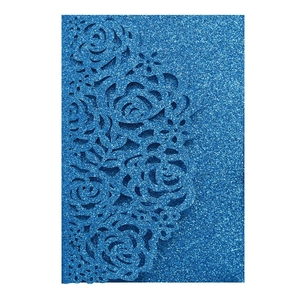 Detail of laser-cut rose patterns on blue glitter wedding invitation cover card