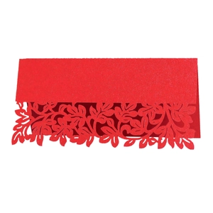 Macro shot of red laser-cut wedding place card with intricate leaf texture and fold line