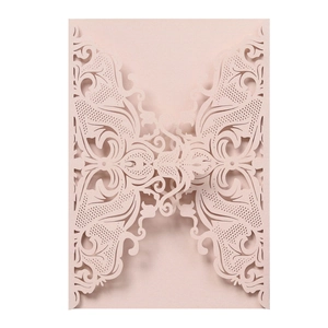 Close-up of laser-cut hollow butterfly wedding invitation in pearlescent pink cardstock