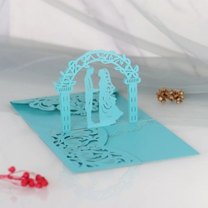 Detail of laser cut 3D wedding invitation featuring bride and groom silhouette in blue